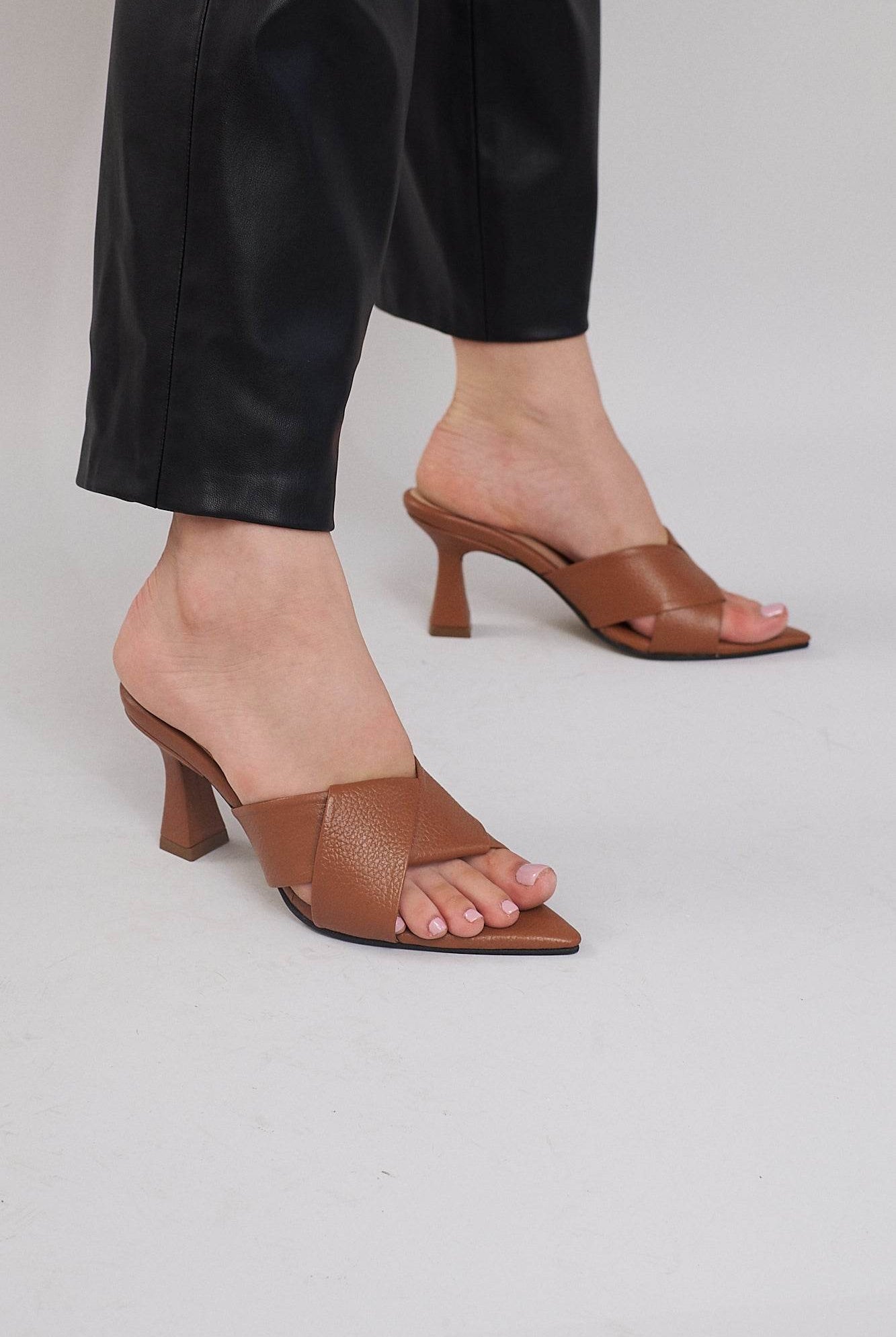 Brown open-toe heeled sandals with wide crisscross leather straps and flared heels