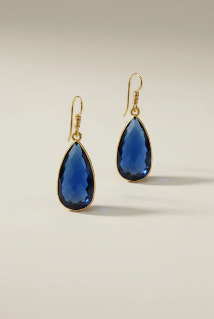Aurea Drop earring Gold jewelry earrings with blue stones on a beige background