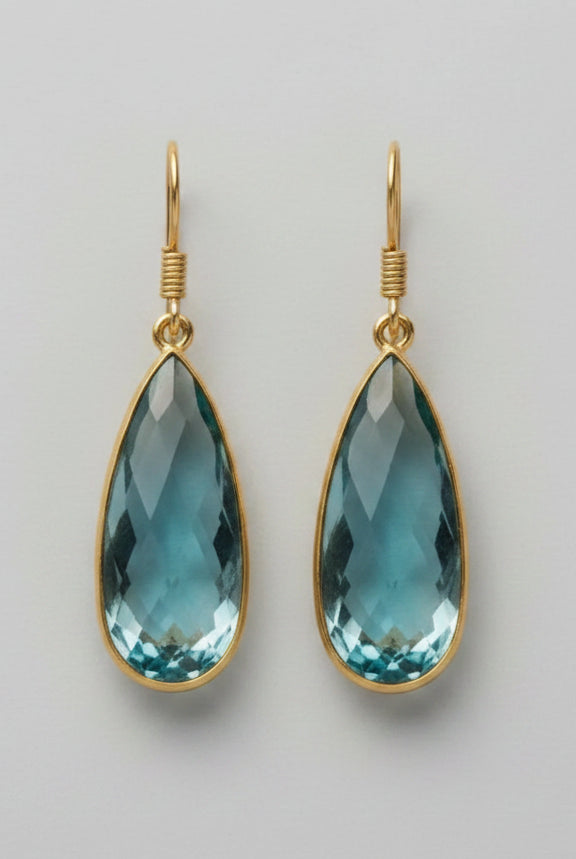 Emilia Merz Aurea drop earrings featuring faceted soft teal teardrop gemstones in an 18K gold-plated bezel setting.