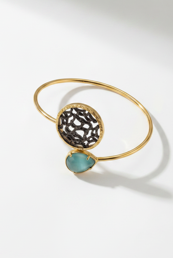 Golden bracelet with blue gemstone on light background from emilia merz