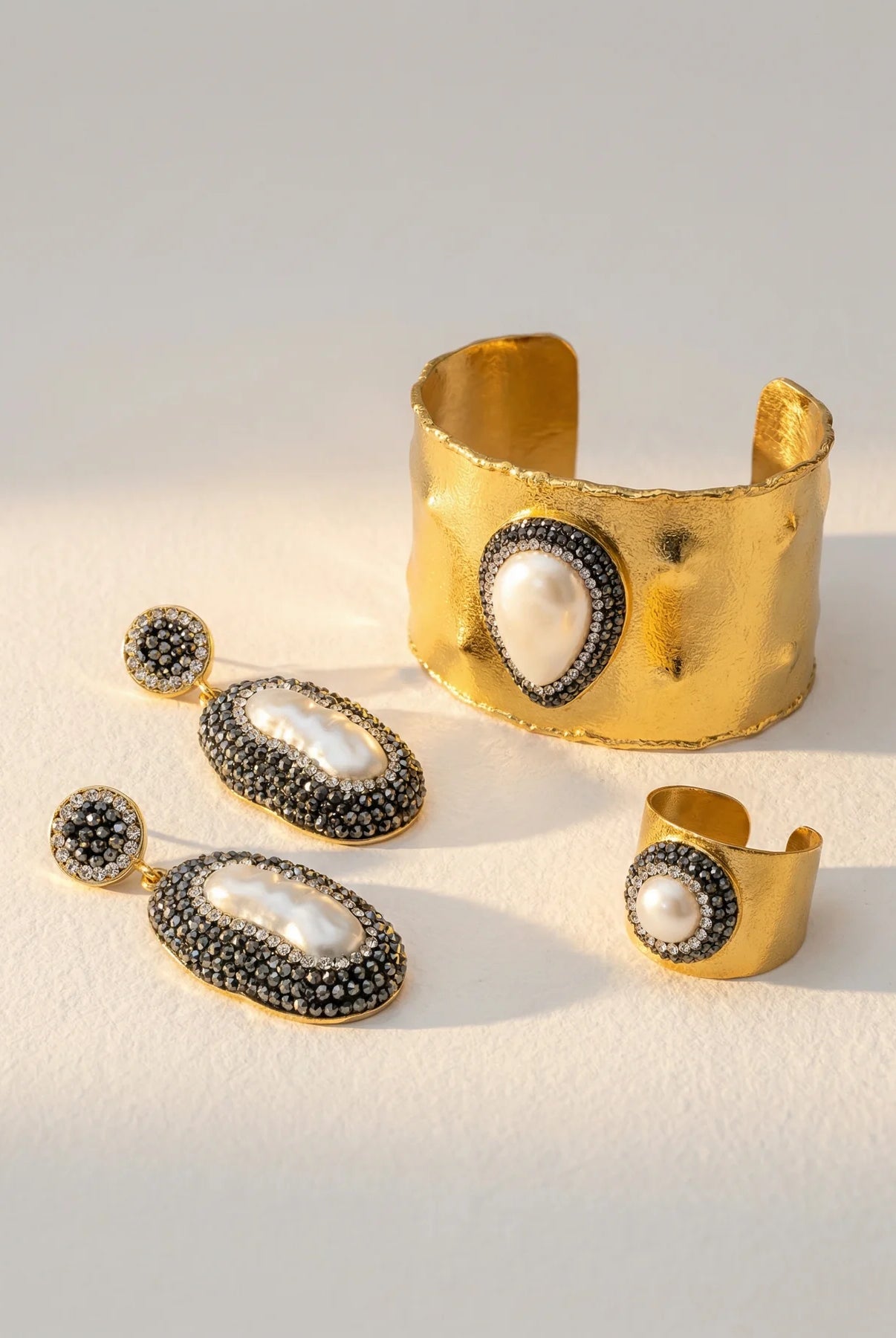 Close-up of the Pearl Aura Cuff alongside the matching earrings and ring.