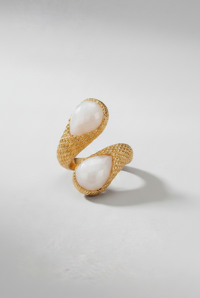 Emilia Merz Serpenté Lumina ring featuring a sculptural gold wrap design with light-toned faceted stones, worn on a model.