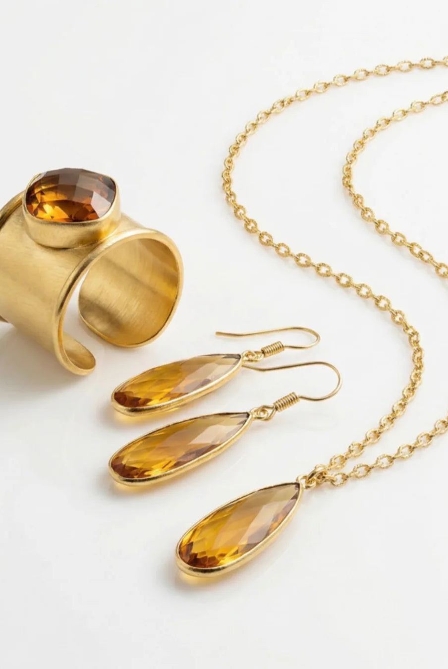 The Aurea drop earrings paired with the matching Emilia Merz statement necklace, showcasing the complete golden amber jewelry set.