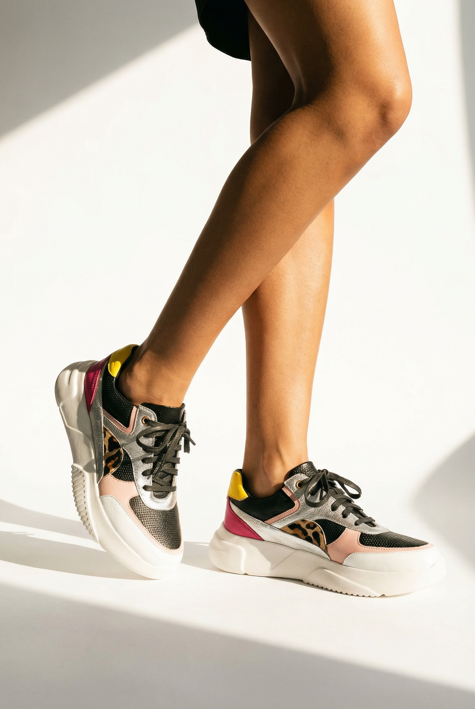 Person wearing colorful sneakers on a light background