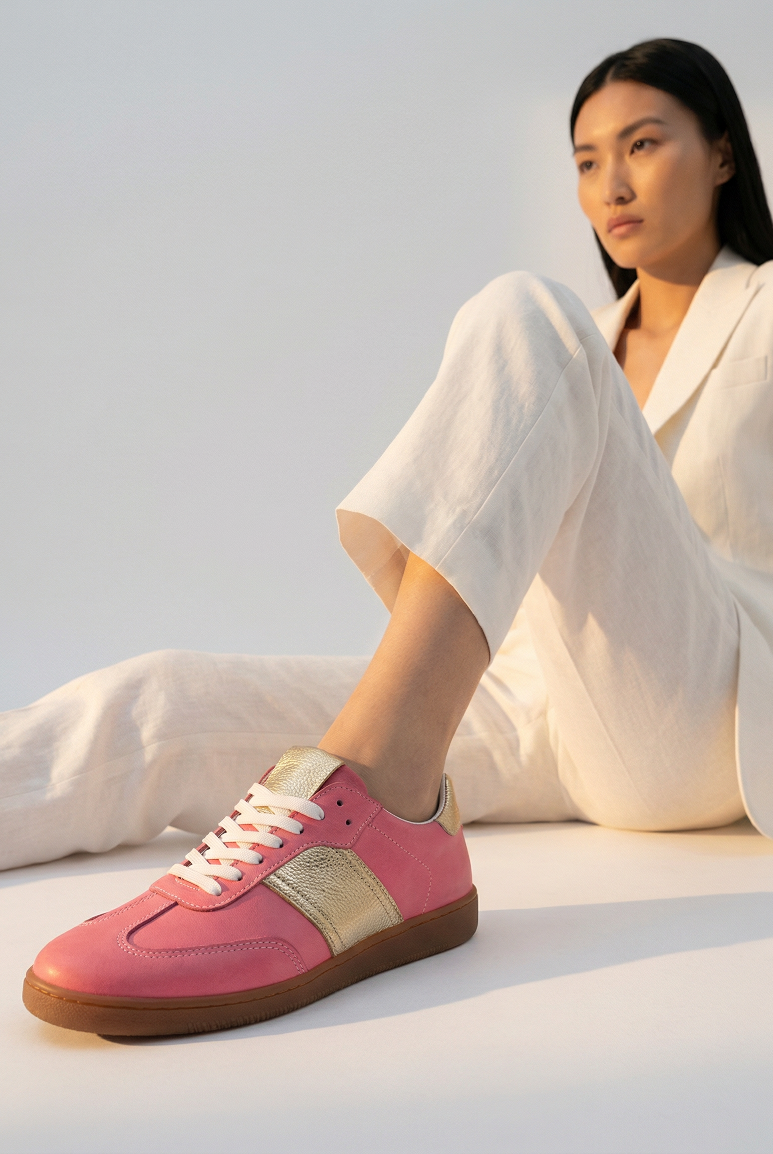 Person wearing pink sneakers for women with a white background