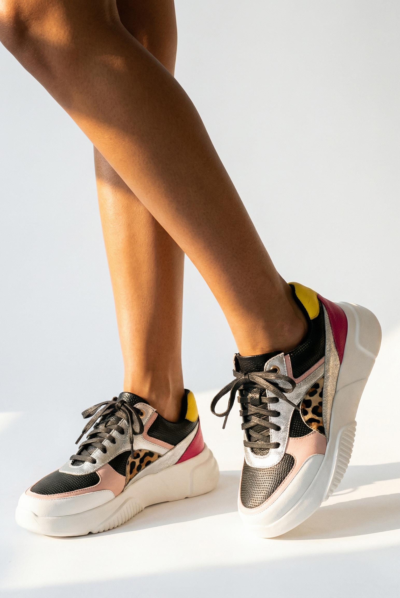 Person wearing multicolor sneakers on a white background
