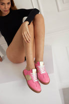 Side view of Sky Runner pink GAT sneakers on model in black body, women’s German Army Trainers