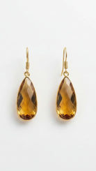 Emilia Merz Aurea drop earrings featuring golden amber teardrop-shaped faceted stones set in 18K gold plating.