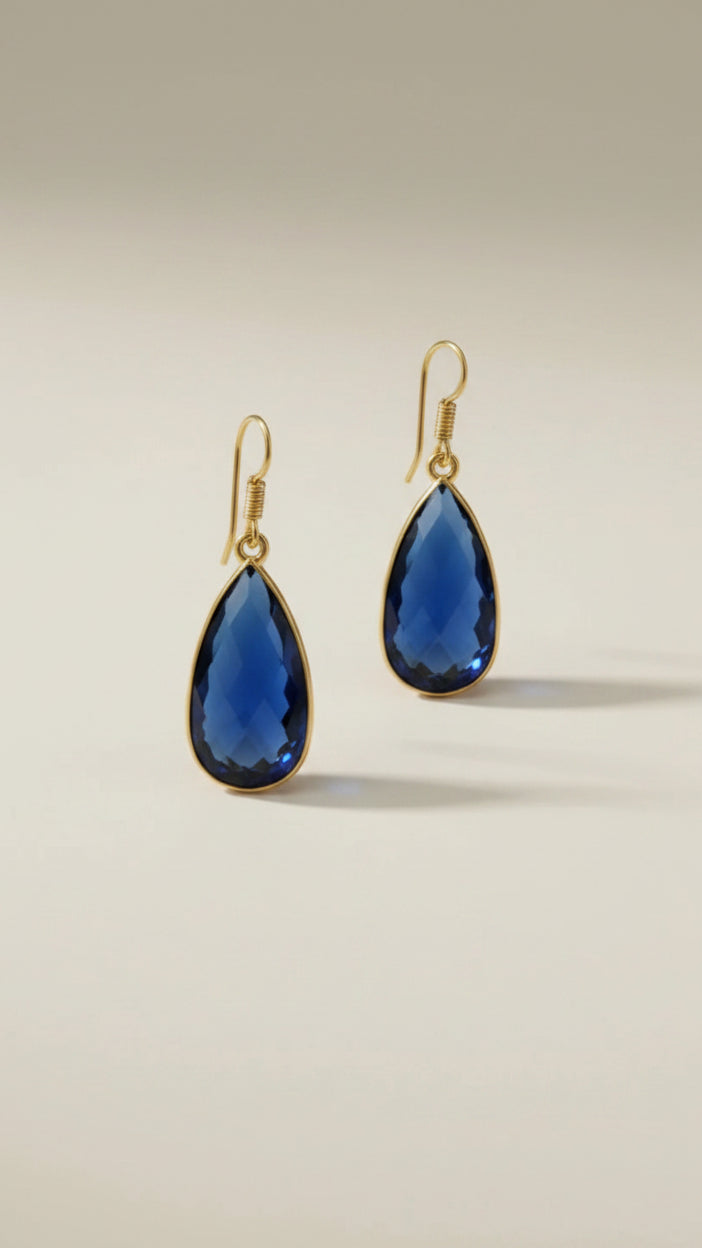 Aurea Drop earring Gold jewelry earrings with blue stones on a beige background
