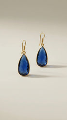 Aurea Drop earring Gold jewelry earrings with blue stones on a beige background
