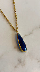 Close-up of the Aurea midnight blue statement necklace, highlighting the detailed facets of the gemstone and the polished gold setting.