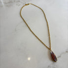 Emilia Merz Aurea pendant necklace featuring a deep violet teardrop-shaped faceted stone set in 18K gold plating on a delicate chain.