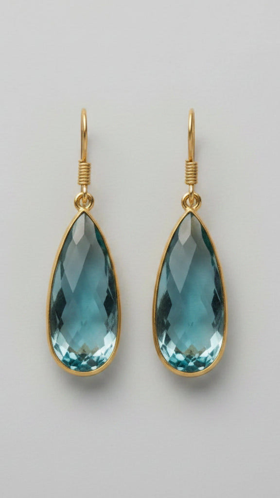 Emilia Merz Aurea drop earrings featuring faceted soft teal teardrop gemstones in an 18K gold-plated bezel setting.