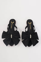 Comfortable black flat sandals for women with statement bow and pearl detailing.