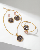 The Lumina Drop Cuff in Peach styled alongside matching filigree medallion jewelry.