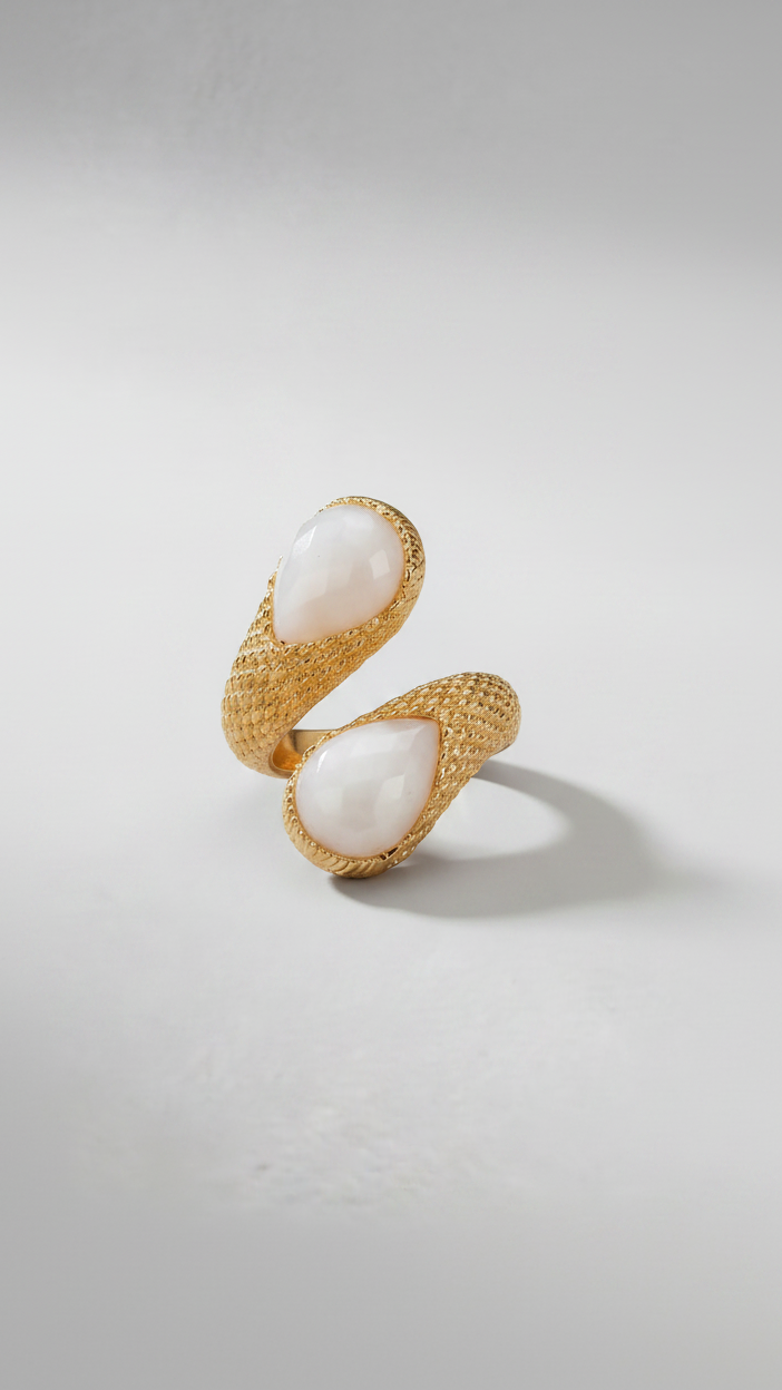 Emilia Merz Serpenté Lumina ring featuring a sculptural gold wrap design with light-toned faceted stones, worn on a model.