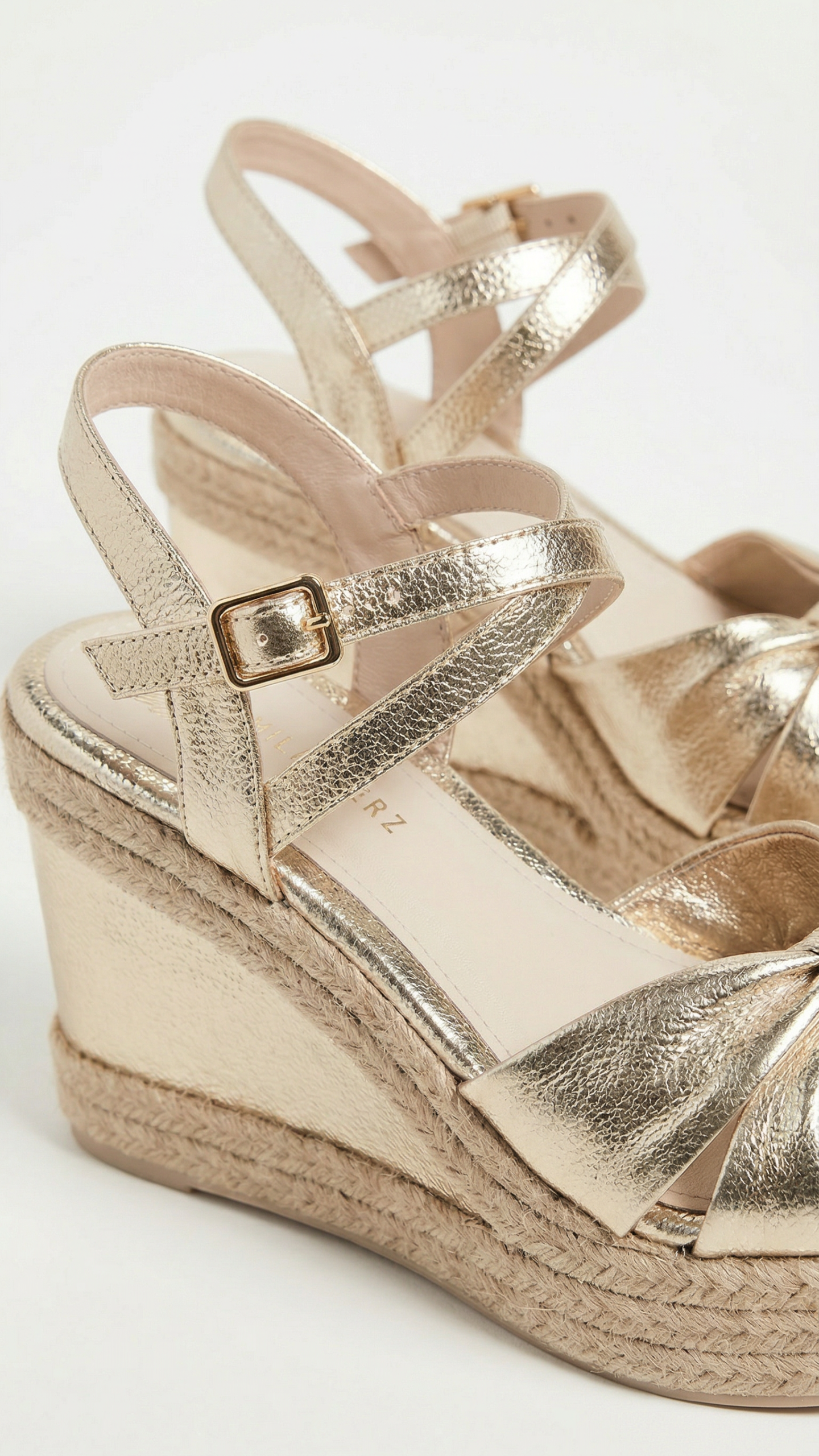 Gold wedge sandal with espadrille sole on a white background