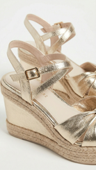 Gold wedge sandal with espadrille sole on a white background