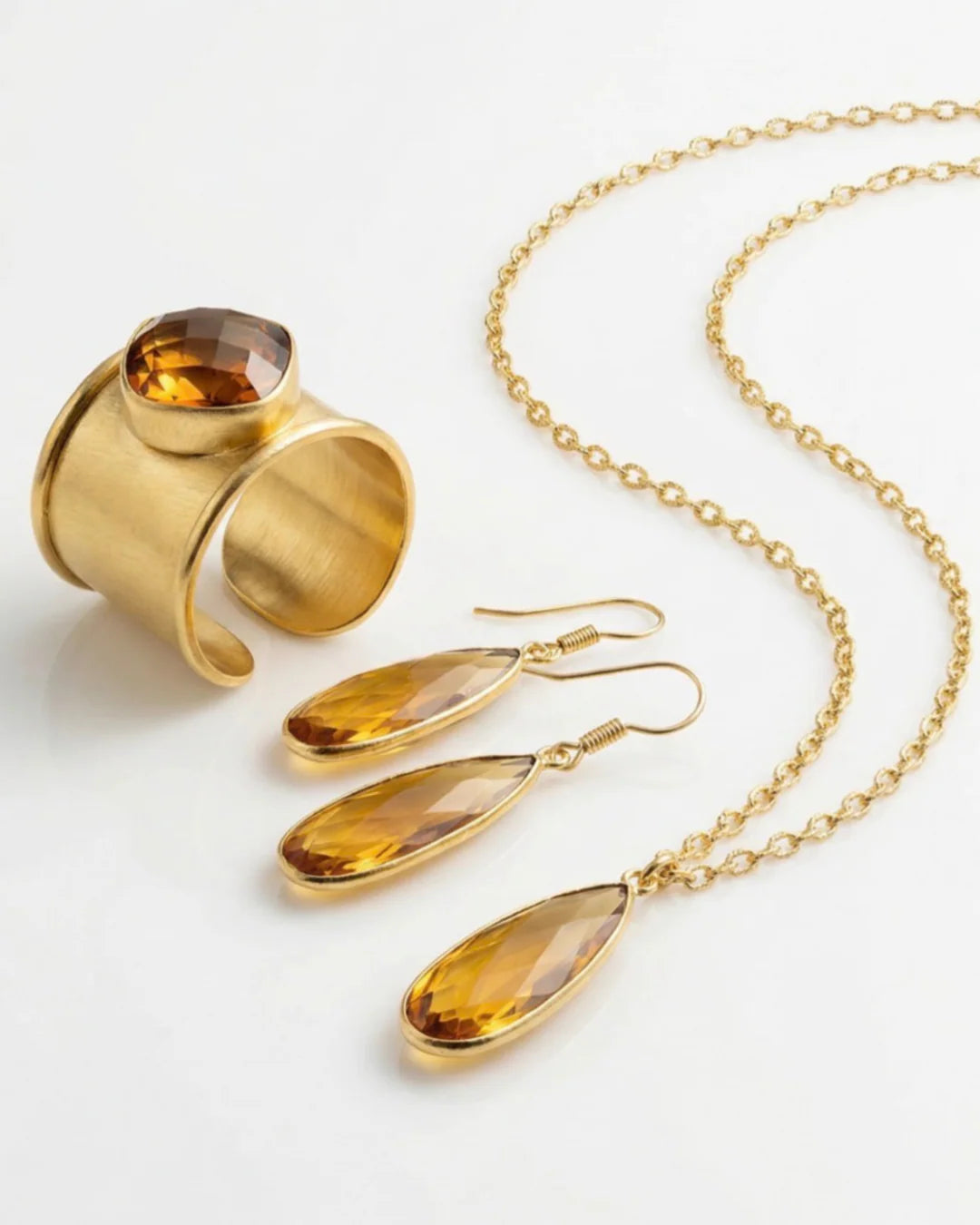 The Aurea drop earrings paired with the matching Emilia Merz statement necklace, showcasing the complete golden amber jewelry set.