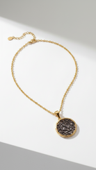 Emilia Merz Lumina Medallion Necklace featuring an intricate gold filigree pendant on a delicate chain.