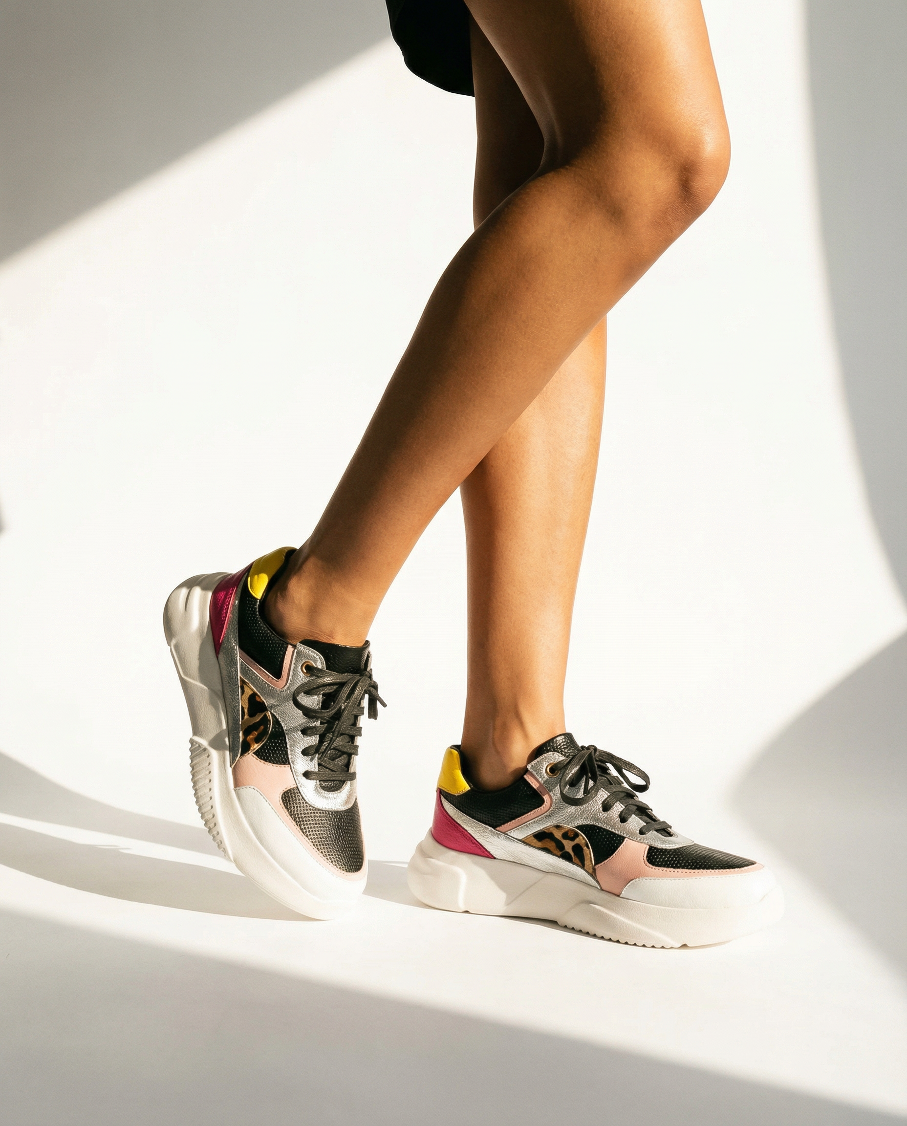 Person wearing colorful sneakers on a light background
