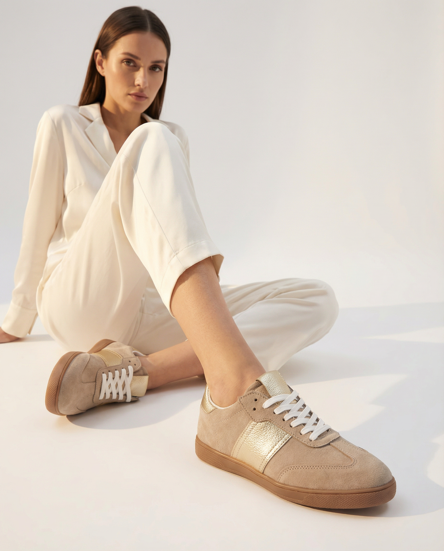 Woman wearing beige sneakers with a white background