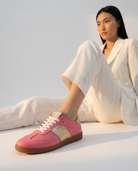 Person wearing pink sneakers for women with a white background