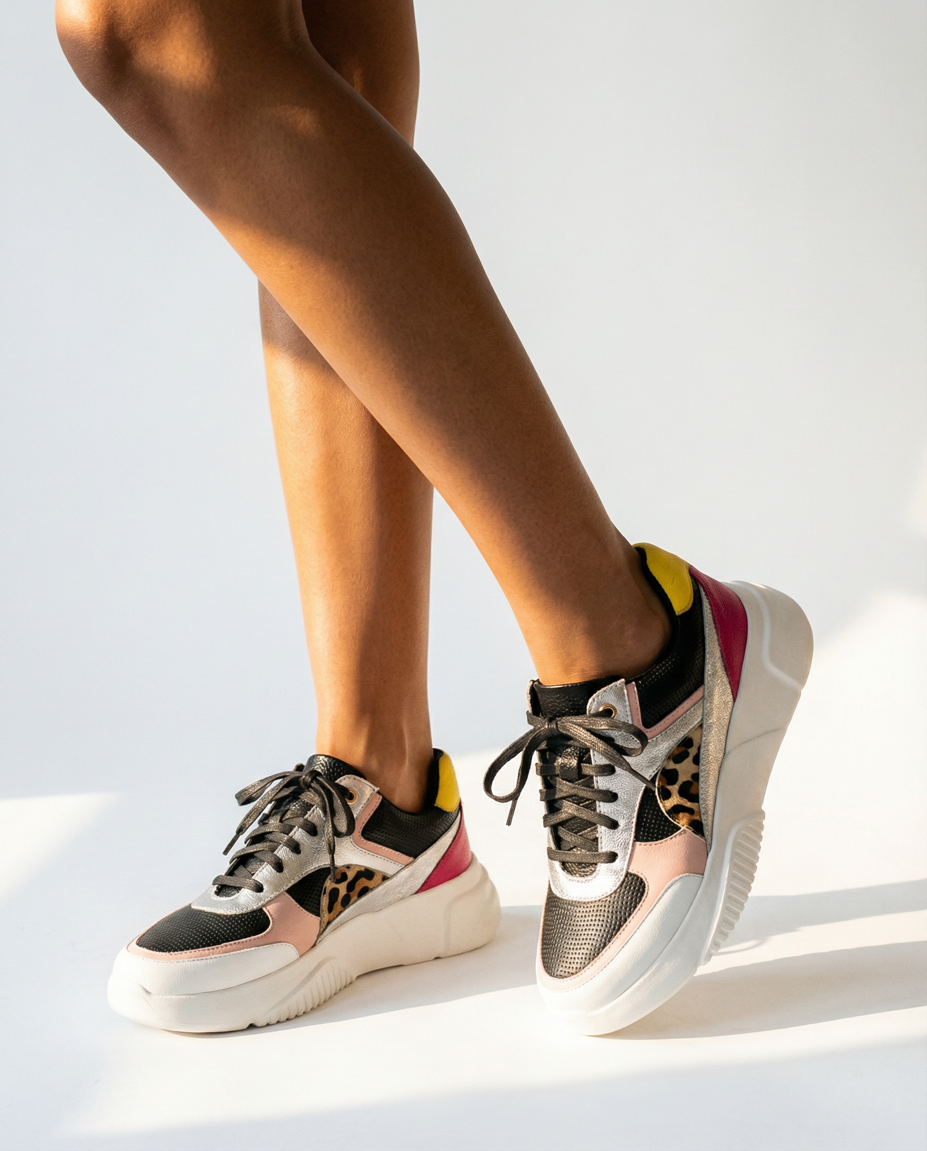 Person wearing multicolor sneakers on a white background