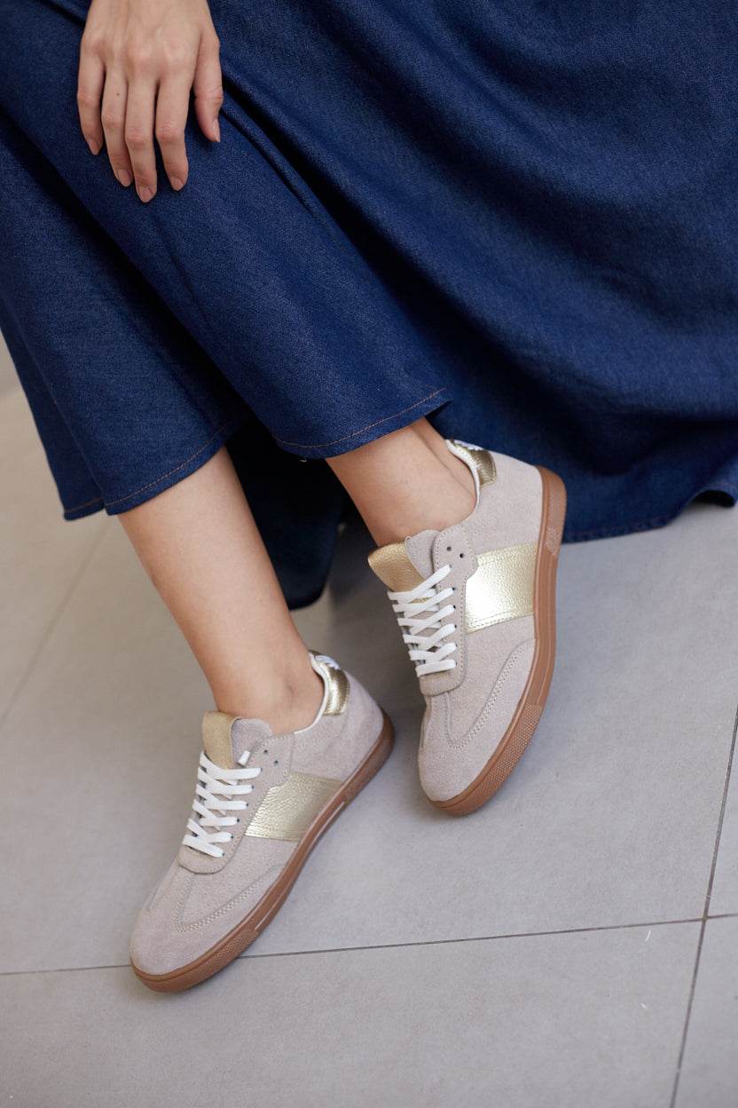 Side view of Sky Runner beige suede sneakers on feet, paired with flowing blue dress
