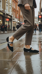 Person wearing a suit and black mary janes on a city street