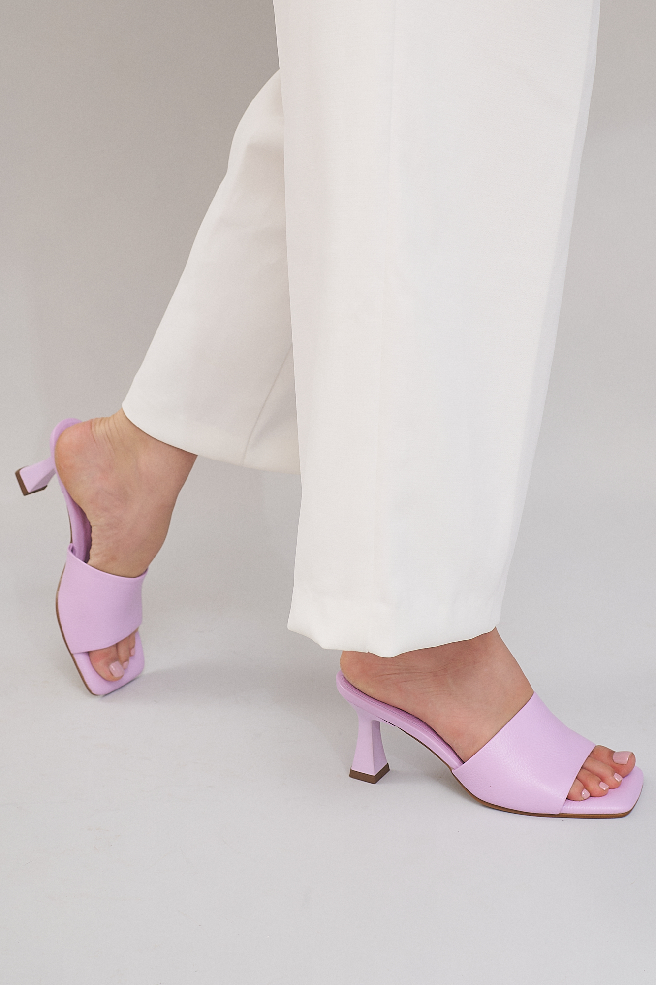 women with white pants wearing lavender peep toe heels from emilia merz